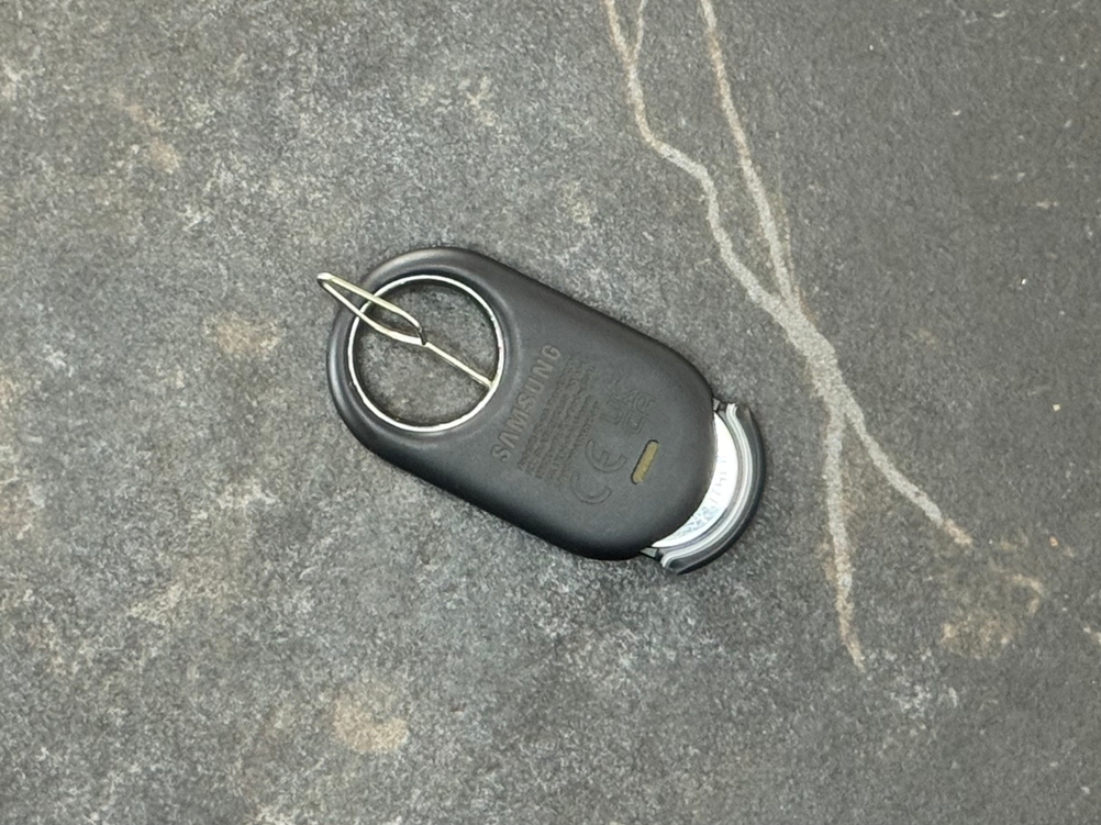 Eine Pin-Nadel steckt im getesteten Schlüsselfinder von Samsung, um das Batteriefach zu öffnen.