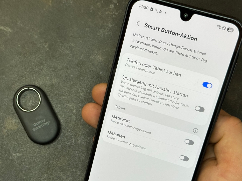 Eine Person hält ein Handy neben den getesteten Schlüsselfinder von Samsung.