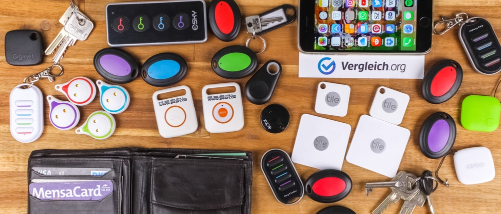 Schlüsselfinder-Test: Mehrere Schlüsselfinder, Schlüssel und Geldbeutel liegen auf einem Tisch.