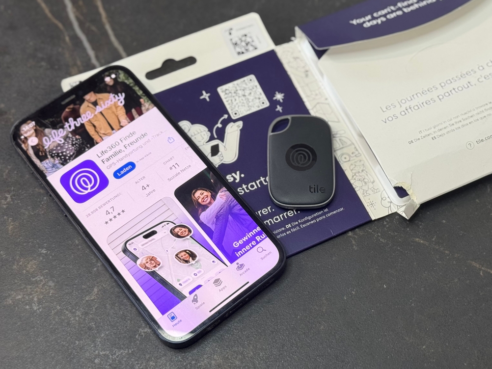 Ein Smartphone mit der passenden App des getesteten Schlüsselfinders von Tile liegt auf dessen Verpackung.