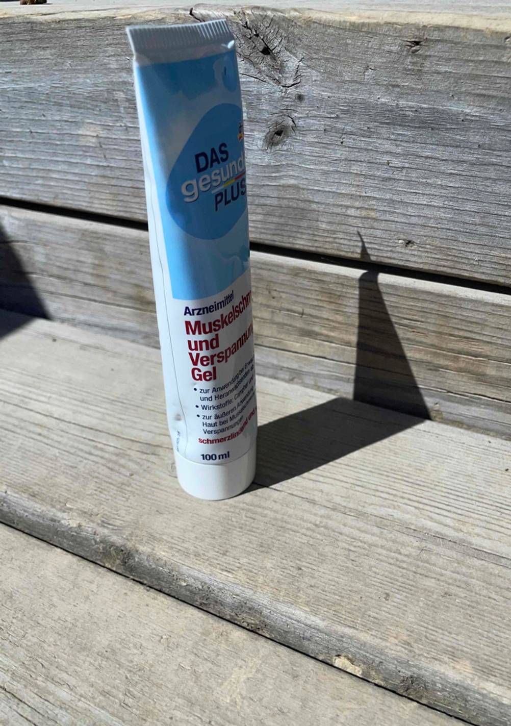 Auf einem Holzboden steht ein getestetes Schmerzgel.