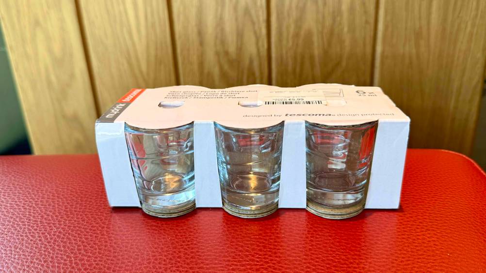 Eine Packung der getesteten Schnapsgläser steht auf einem roten Polster.