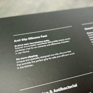 Ein Abschnitt der Verpackung zeigt den Hinweis auf die rutschfesten Silikonfüße des Redsalt-Bambusbretts auf Deutsch und Englisch.