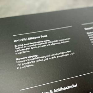 Ein Abschnitt der Verpackung zeigt den Hinweis auf die rutschfesten Silikonfüße des Redsalt-Bambusbretts auf Deutsch und Englisch.