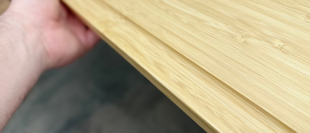 Eine Nahaufnahme zeigt eine Seite des Redsalt-Bambusbretts mit eingelassener Saftrille und eingraviertem Logo.