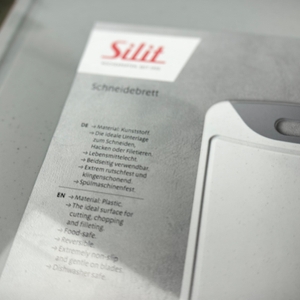 Nahaufnahme der Verpackungsbeschreibung zum Silit-Schneidebrett 21.4223.5354 mit Infos zu Material, Eigenschaften und Spülmaschineneignung.