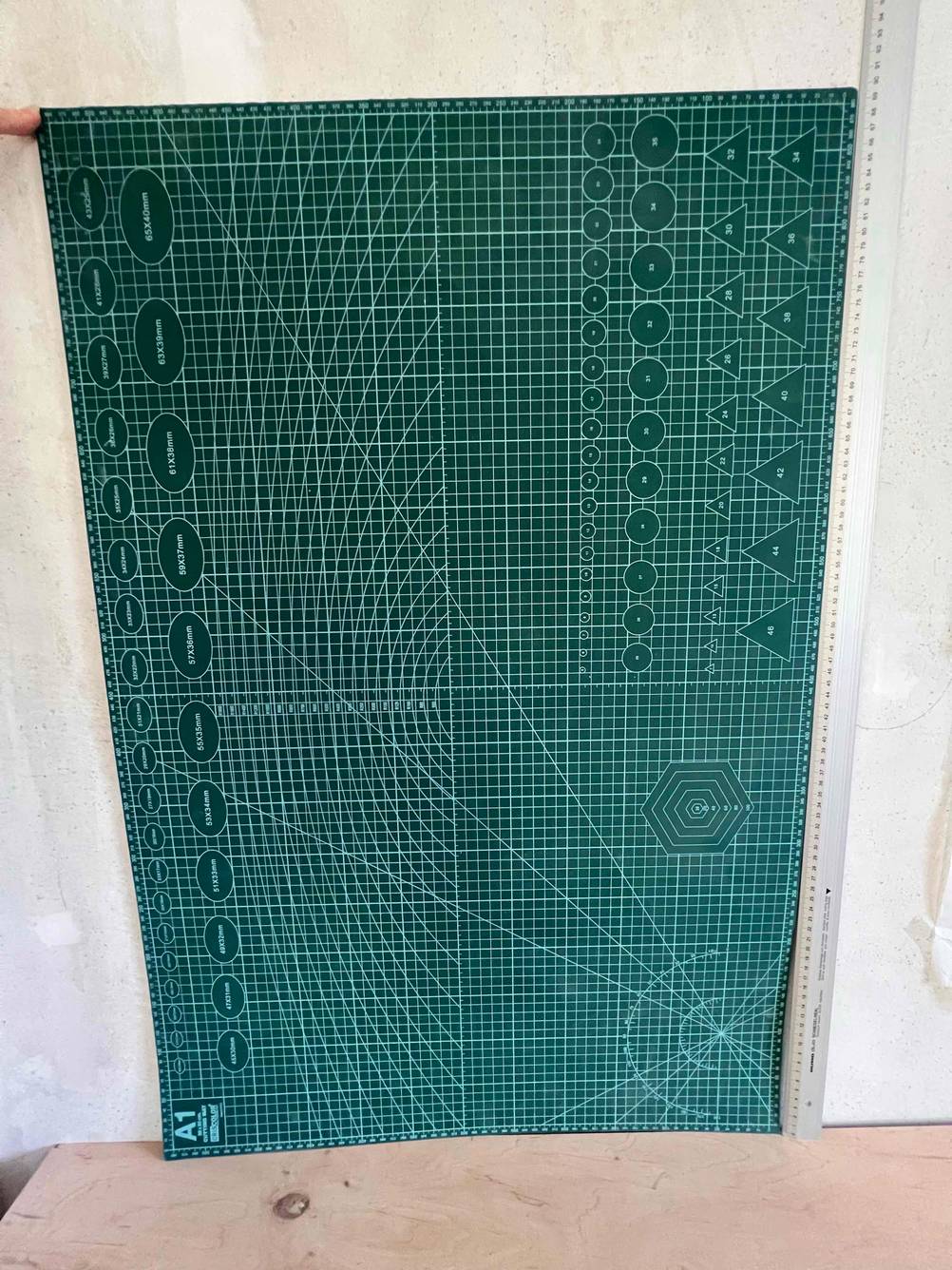 Eine getestete Schneidematte im A1-Format liegt an einer Wand an.