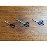 Drei Schneiderscheren liegen nebeneinander auf einem Tisch