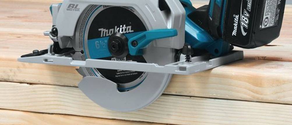 Eine Makita-Kreissäge mit Akku am Rand eines Stapels Holzlatten.