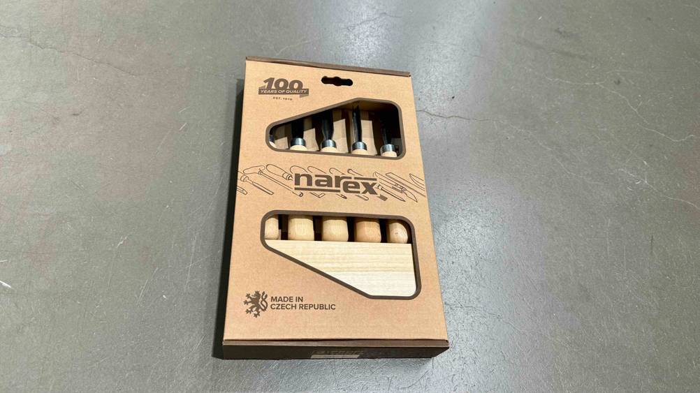 Ein getestetes Schnitzwerkzeug liegt in der Originalverpackung auf einem Betonboden.