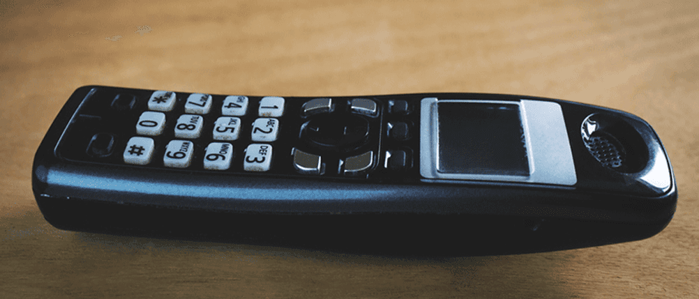 Ein schnurloses Telefon liegt auf Holz.