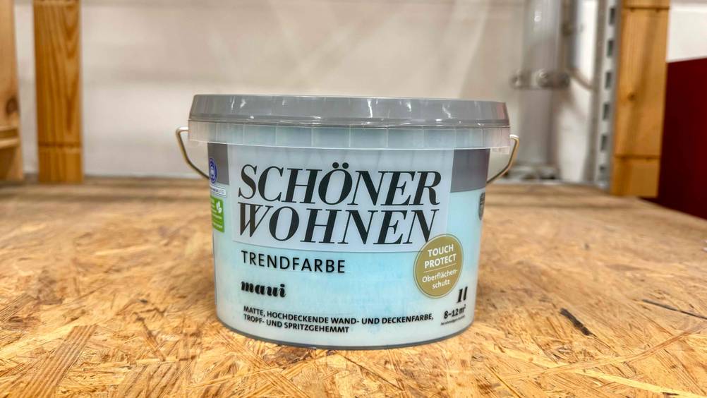 Ein Kübel der Schöner-Wohnen-Wandfarbe im Test auf einem Holzbrett.