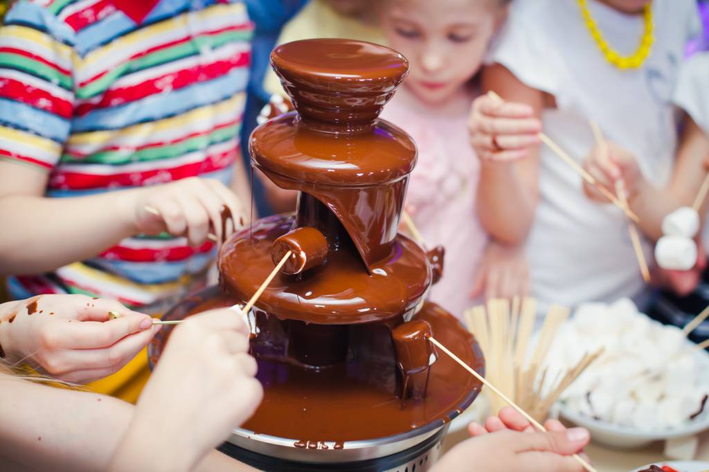 Schokofondue-Test: Mehrere Kinder stehen um ein Schokofondue. 