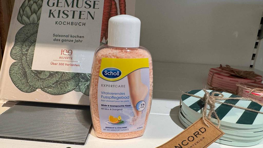 Ein getestetes Scholl-Fußbadesalz in einer Kunststoffflasche steht auf einem Regal im Geschäft.