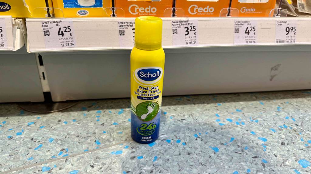 Im Test: Ein Fußdeodorant in der Sprühflasche steht vor einem Verkaufsregal.