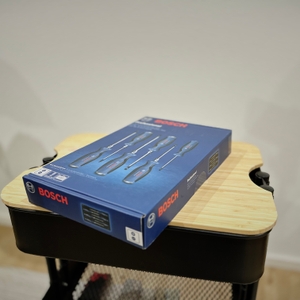 Der geschlossene Karton des Schraubendreher-Sets von Bosch liegt auf einem Rollwagen.