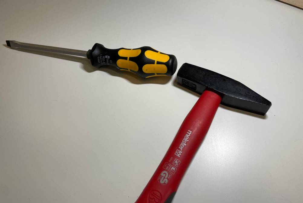 Schraubendreher-Set im Test: Ein Schraubenzieher und ein Hammer auf einer hellen Fläche.