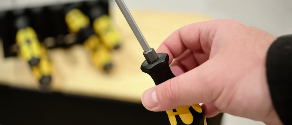 Eine Person hält einen Schraubendreher von Wera in der Hand.