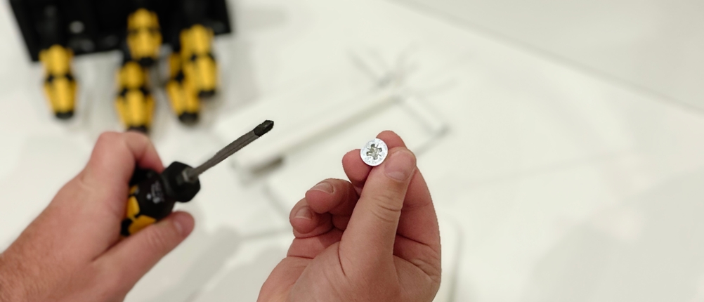 Eine Schraube soll mit einem Schraubendreher von Wera eingeschraubt werden.