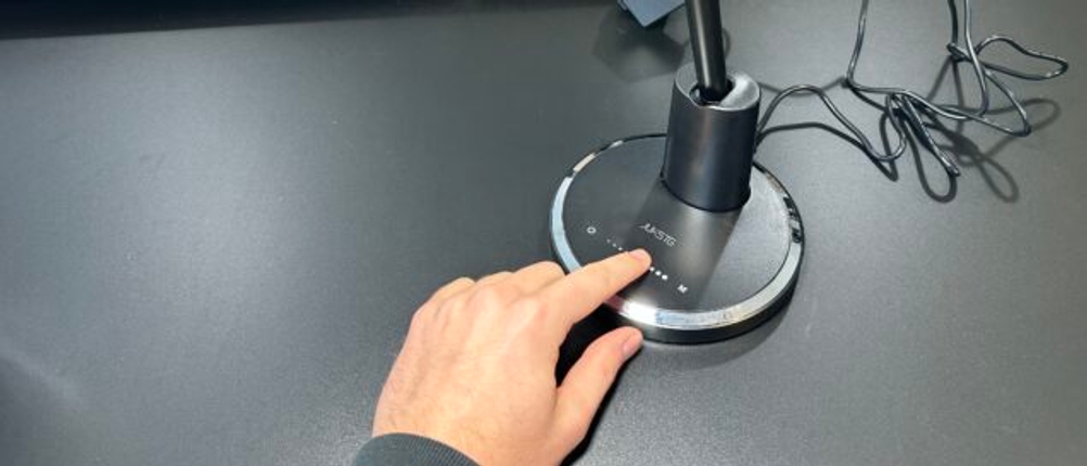 Eine Hand berührt das Touch-Bedienfeld der Jukstg-HD1906C-Schreibtischlampe, um die Helligkeit anzupassen.