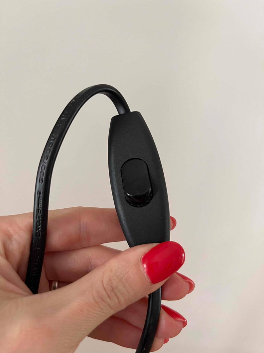 Kinder-Schreibtischlampen getestet: Eine Hand hält den Anschalter am Kabel nach oben.