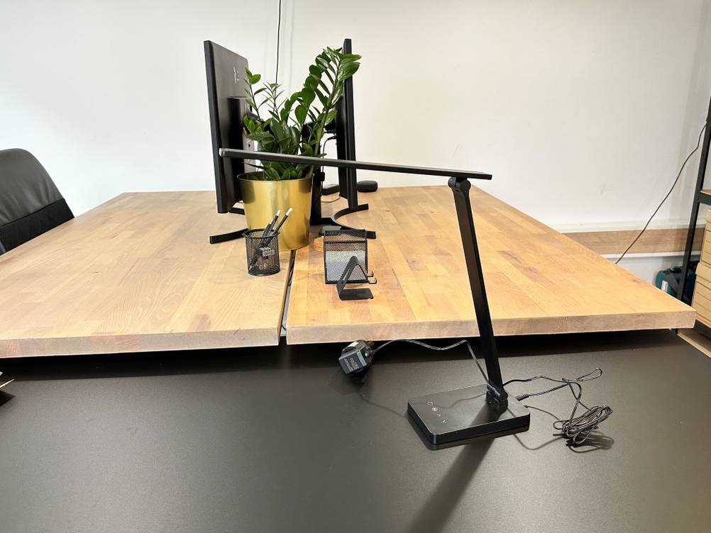 Die Schreibtischlampe von Lepro steht aufgebaut auf dem Tisch.