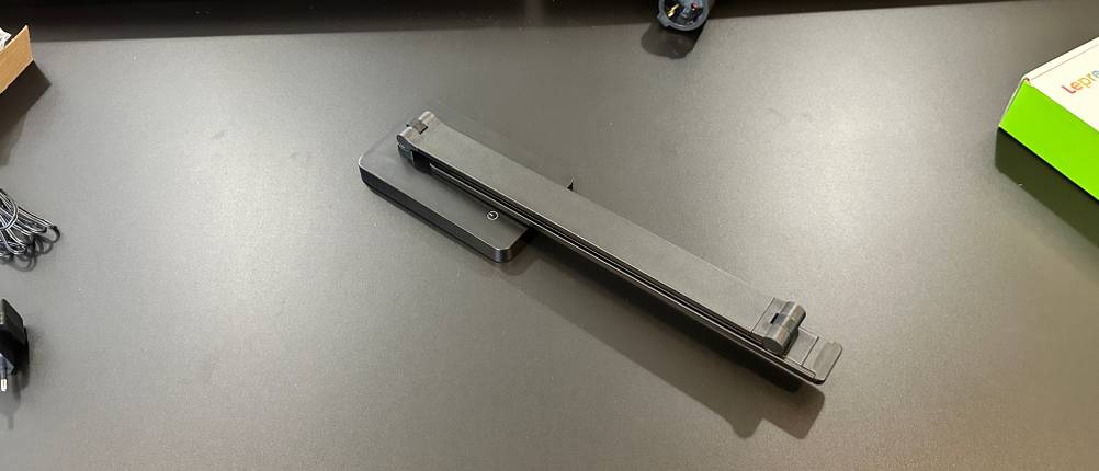 Die zusammengeklappte Lepro LED Schreibtischlampe liegt einzeln auf einem schwarzen Tisch und ist bereit zur Inbetriebnahme.