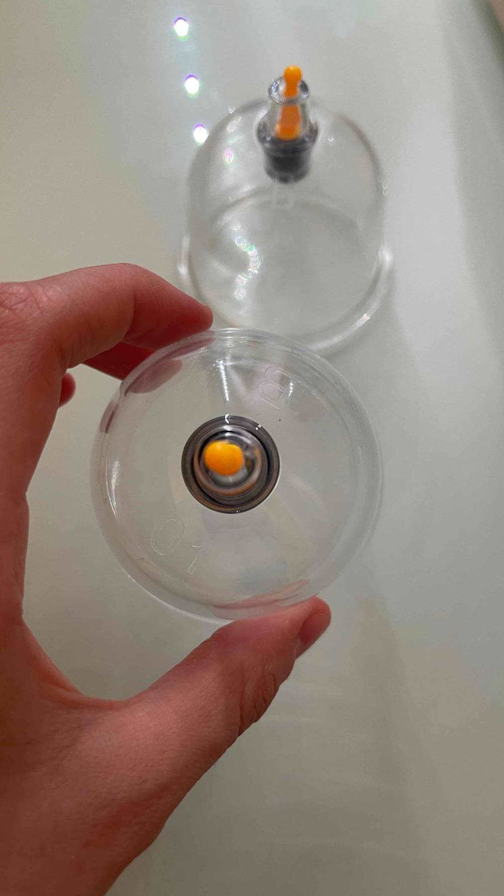 Eine Hand hält ein getestetes Schröpfglas.