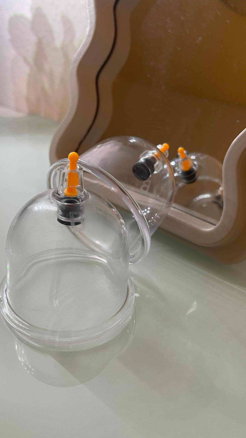 Ein getestetes Schröpfglas steht vor mehreren liegenden im Hintergrund.