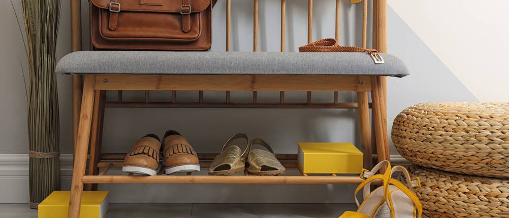 Schuhbank-Test: Eine Holz-Schuhbank mit grauem Sitzpolster steht in einem modernen Flur.