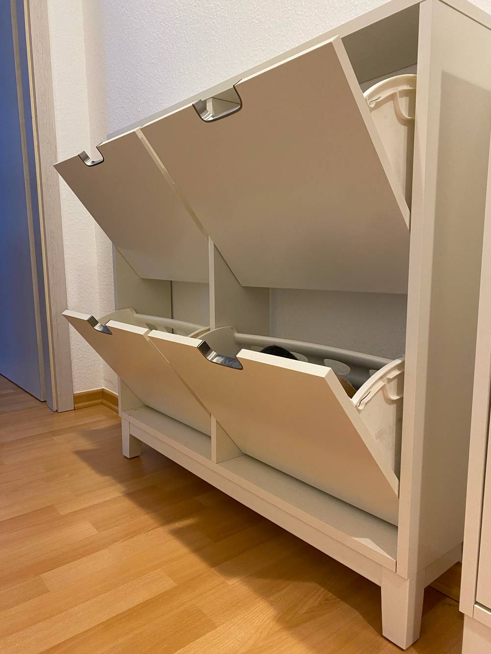 Ein getesteter Schuhschrank von schräg seitlich mit geöffneten Fächern vor einer weißen Wand.
