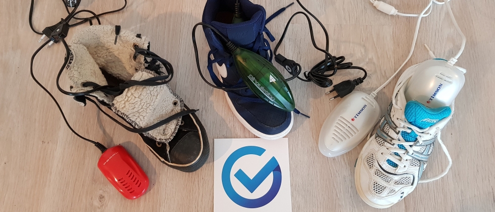 Drei Schuhtrockner mit kleinen Heizmodulen und zusammen mit drei Schuhen auf dem Boden