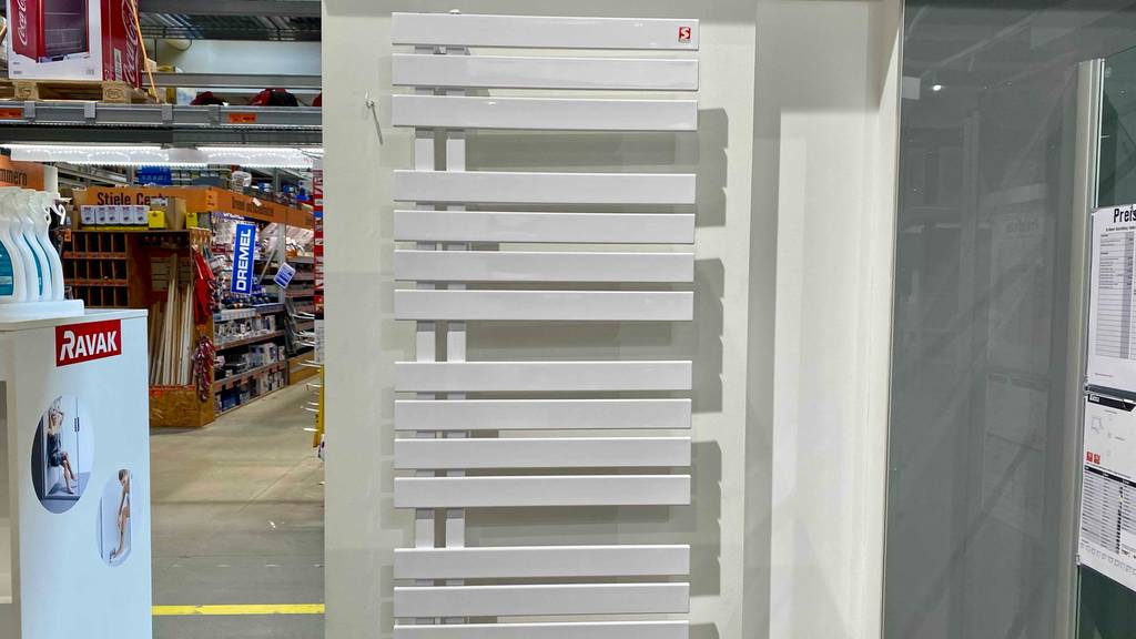 Frontansicht eines elektrischen Badheizkörpers, der zum Testen an einer weißen Wand hängt.