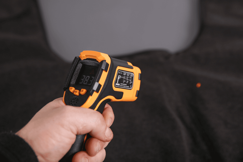 Mit einem Laser-Thermometer wird die Oberflächentemperatur eines Schulterwärmers getestet.