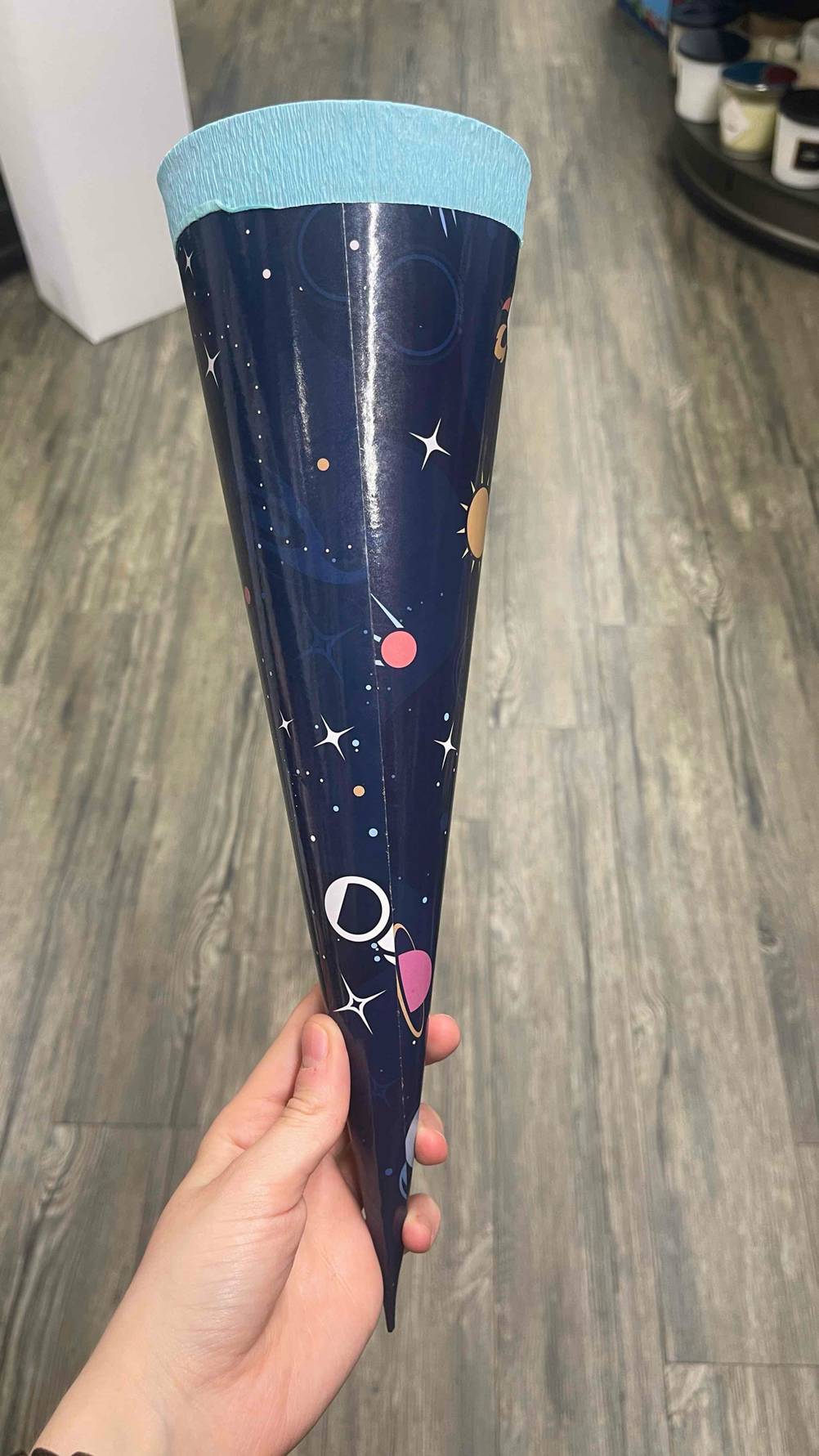 Im Test: Eine Hand hält eine Schultüte in blau.