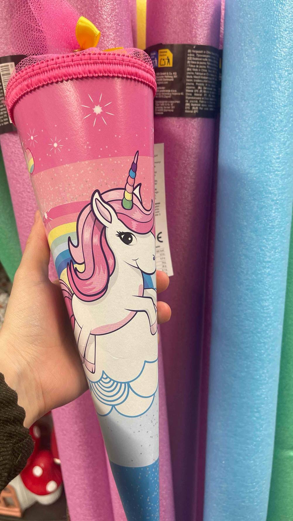 Eine Hand hält eine Schultüte im Test mit einem Einhorn.