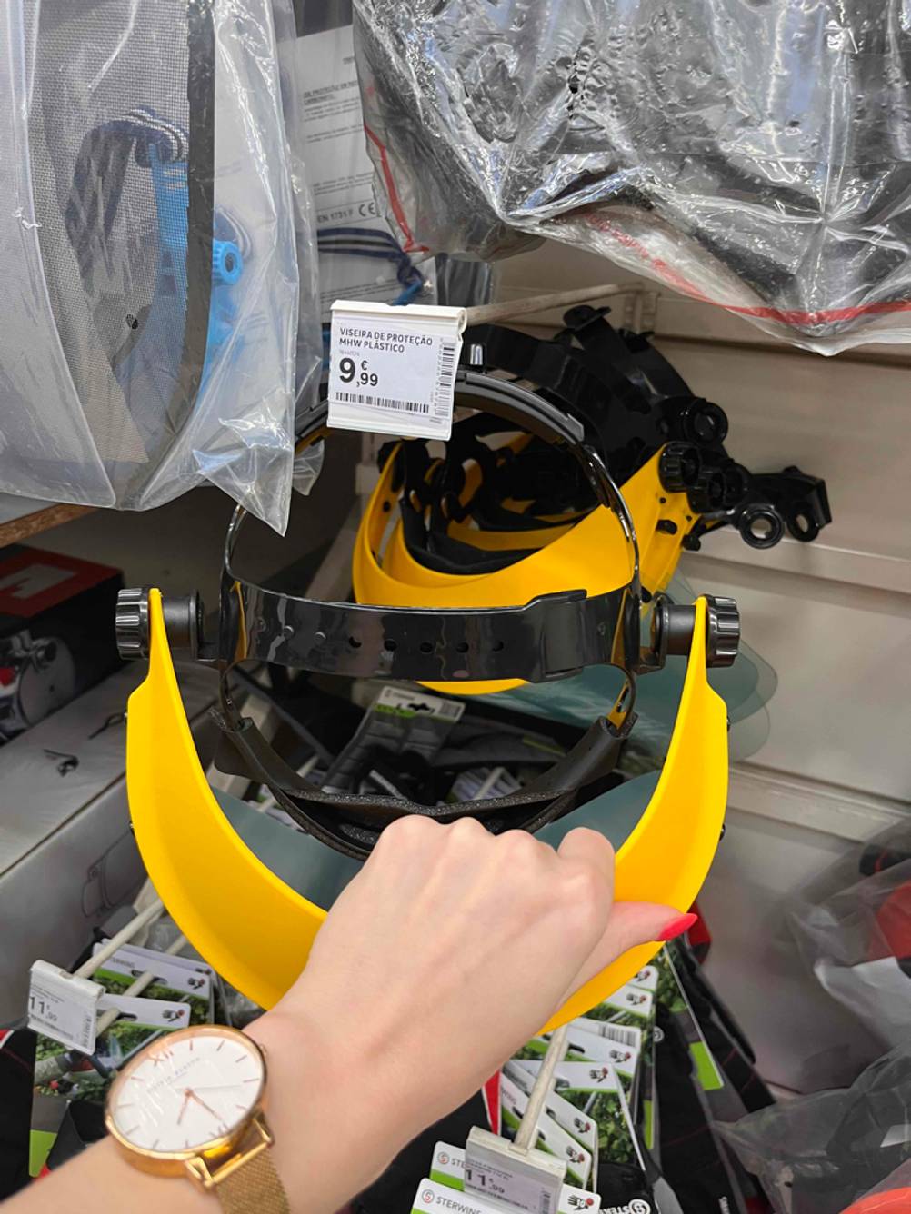 Eine Hand greift eine getestete Schutzbrille für Brillenträger.