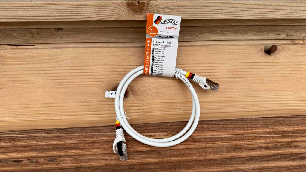 Im Test: Ein Netzwerkkabel Cat 7 in Weiß befindet sich auf einer holzoberfläche.