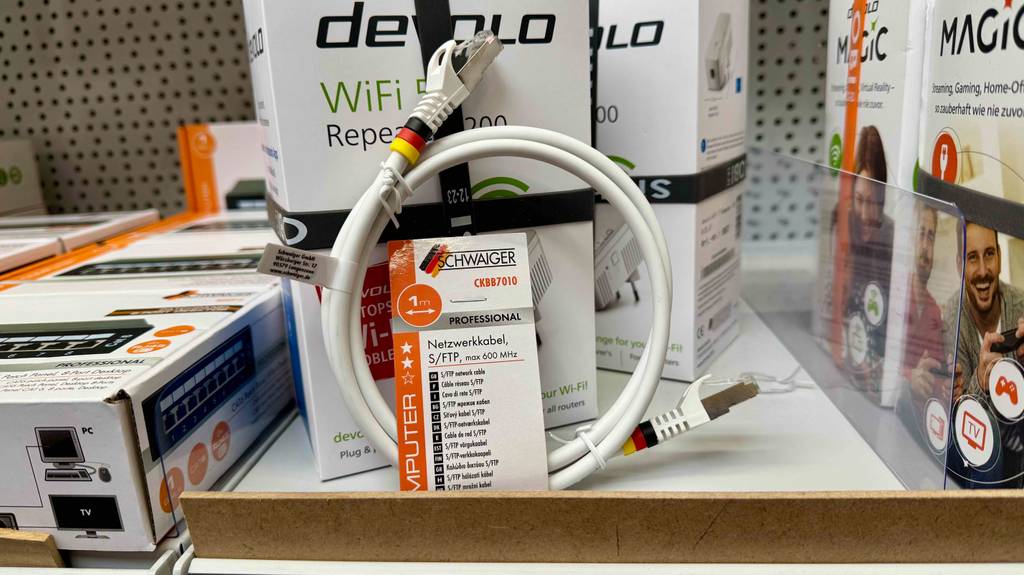 Im Test: Ein Netzwerkkabel Cat 7 lehnt an einem Karton inklusive Repeater, der auf einem Verkaufsregal steht.