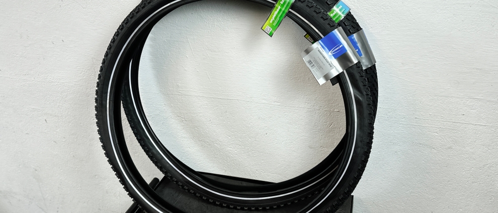 Zwei zusammengelegte Schwalbe-Marathon-Plus-MTB-HS468-Reifen liegen nebeneinander. Die Verpackungsetiketten sind sichtbar.