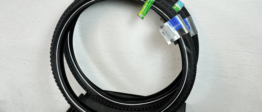 Zwei zusammengelegte Schwalbe-Marathon-Plus-MTB-HS468-Reifen liegen nebeneinander. Die Verpackungsetiketten sind sichtbar.