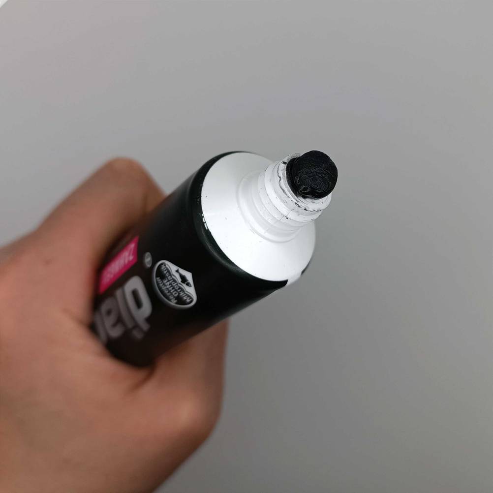 Zahnpastatube in einer Hand