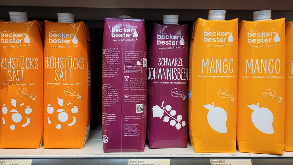 In einem Regal stehen mehrere Packungen des schwarzen Johannisbeersaftes neben anderen Sorten.