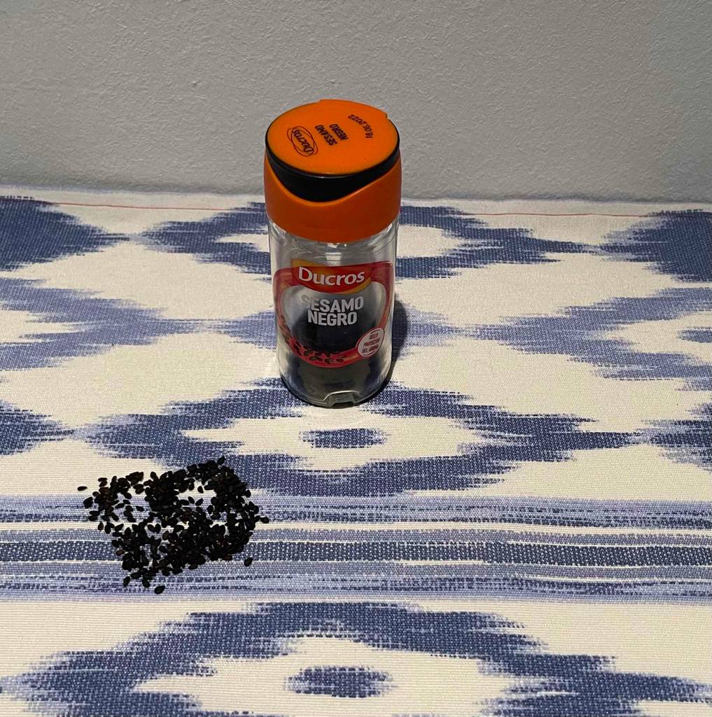 Getesteter schwarzer Sesam befindet sich auf dem Küchentisch neben der Verpackung. 