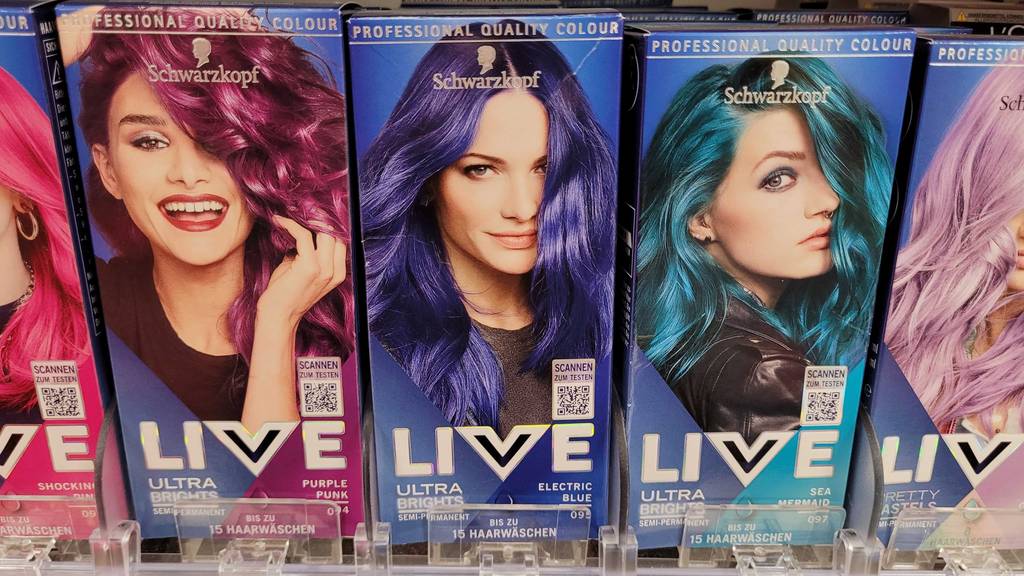 Blaue Haarfarbe im Test: Eine Packung steht zwischen anderen Haarfarben in einem Regal.
