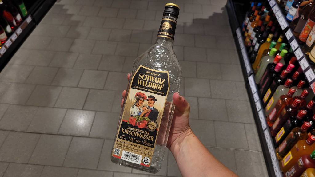 Im Test: Eine Hand hält eine Flasche Kirschwasser.