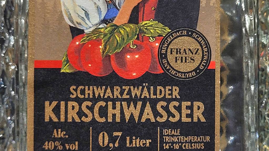 Auf der Vorderseite einer Flasche getestetes Kirschwasser stehen Informationen zur Trinktemperatur.
