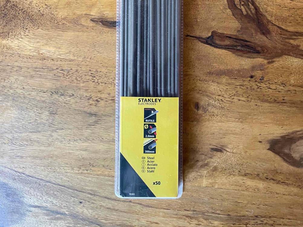 Nahaufnahme der Packung von vorne der Schweißelektroden im Test auf einem Holztisch.