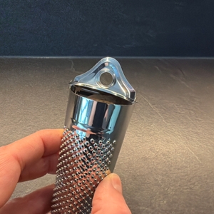 Eine Muskatnuss liegt oben in der Schwertkrone-Muskatreibe