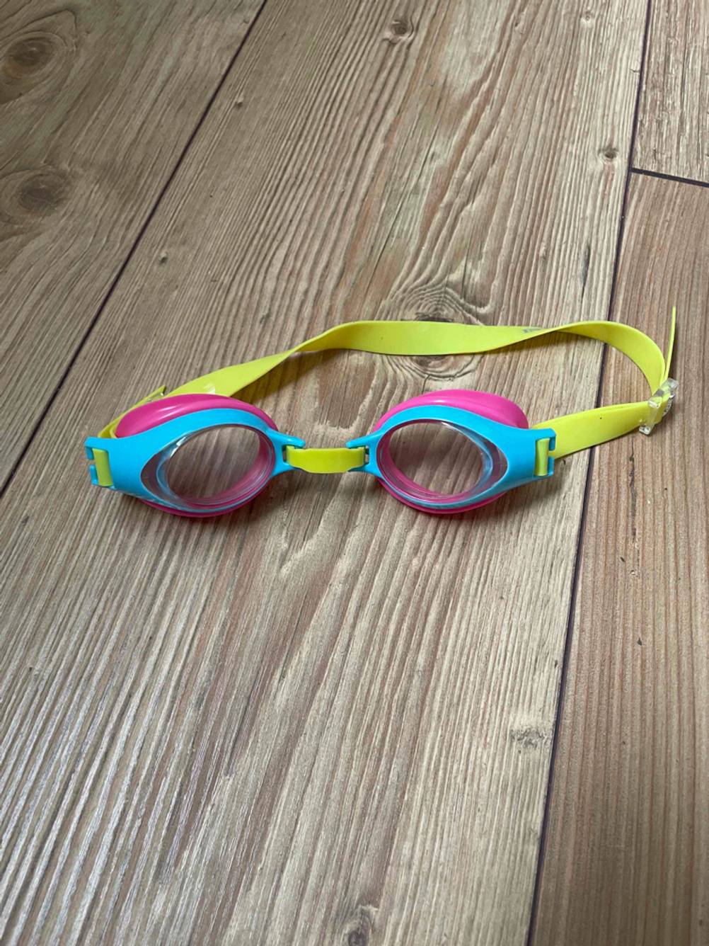 Im Test: Eine Kinder-Schwimmbrille auf einem Holzboden
